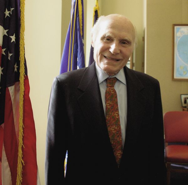Senator Herbert Kohl standing by an American flag in his Washington, D.C. office.
