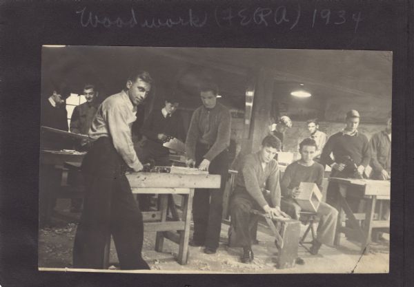 Page from a scrapbook kept by Neighborhood House, with young men in a wood shop using hammers, saws, and other woodworking tools.