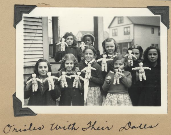 Group portrait of the Orioles, members of a club for ten-year-old girls at Neighborhood House. A former worker at the settlement house then working in a hospital in China had sent rag dolls which the girls stuffed and dressed. The project for the year was studying Chinese culture, raising money, and creating scrapbooks and gifts to send to two girls their age in China.