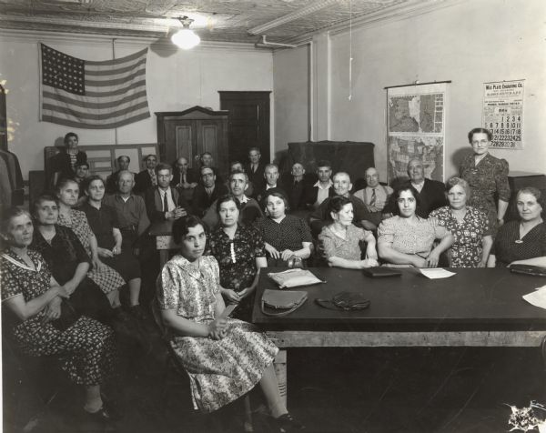 Adult students pose in class at a night school, where they took classes in English and citizenship at Neighborhood House.