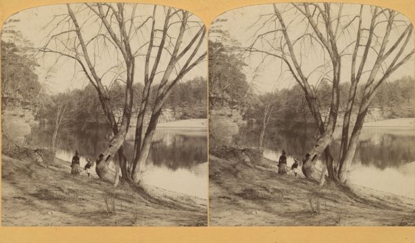 Stereograph of Evaline and Miriam Bennett standing at the edge of a river.