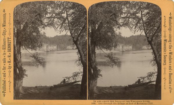 View of the river from the shore, framed by two trees. Text at right: "Wanderings Among the Wonders and Beauties of Wisconsin Scenery."
