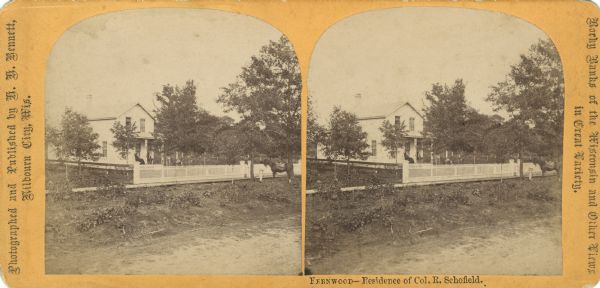 Exterior view from road towards Colonel Schofield's residence. A man and two women are sitting on the porch, and a person and a horse are standing at the gate. Text at right: "Rocky Banks of the Wisconsin and Other Views in Great Variety."