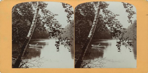 View from shoreline of a man rowing a boat on the Wisconsin River.