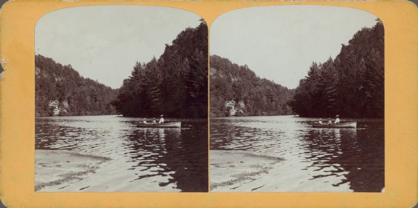 View from shoreline of woman with two children in a rowboat. Probably Harriet with Miriam and Ruth Bennett.