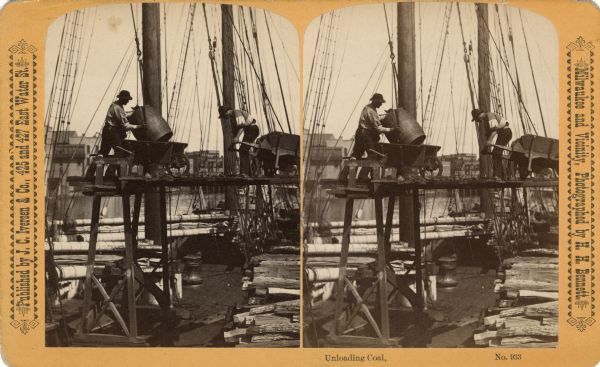 Stereograph of two workers placing barrels of coal onto wheelbarrows to unload off a ship. Text at right: "Milwaukee and Vicinity, Photographed by H.H. Bennett." Text at left: "J. C. Iversen & Co., 425 and 427 East Water St."