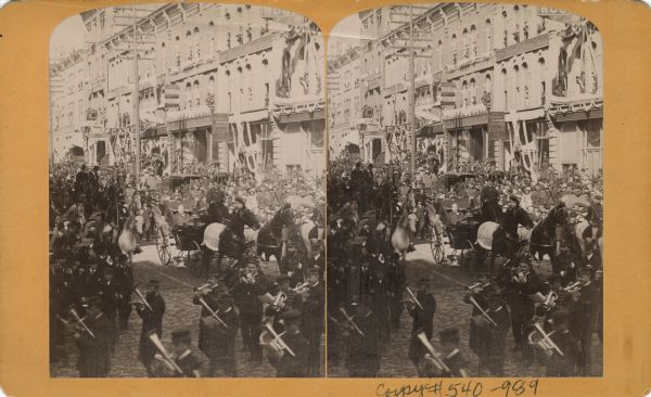 A parade for President Grover Cleveland's Milwaukee visit during his Goodwill Tour. A marching band leads a horse and buggy (possibly carrying the president) down the crowded street.