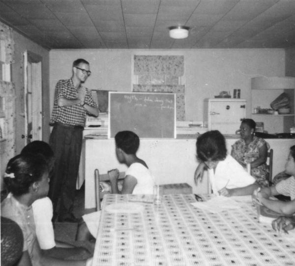 A white male Freedom Summer volunteer teaches African-American students in a Freedom School in Priest Creek Baptist Church.
