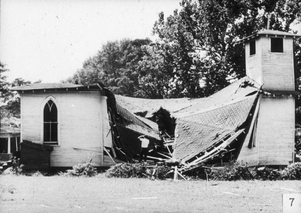 A man stands inside the ruins of a church building. When printed in the N.A.A.C.P. Legal Defense and Education Fund Report, vol. II, no. 1, this photograph bore the following caption: "McComb, Miss.: The Society Hill Missionary Baptist Church, almost demolished September 20th, is one of 36 Negro churches bombed or burned in Mississippi this year. It had been used as a Freedom School. The arrests of over 75 McComb Negroes followed shortly after this incident and the bombing of the home of Mrs. Alyene Quin the same night... The Pike County sheriff later told Rev. Taylor, pastor of the bombed church, 'You niggers is just bombing one another.'"