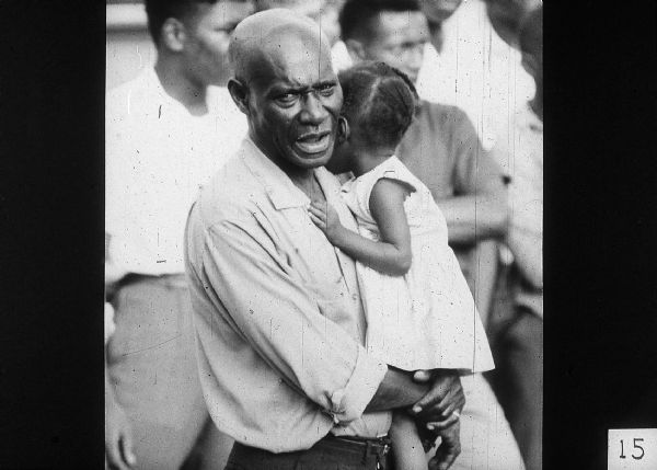 A man holds a young girl in his arms.
