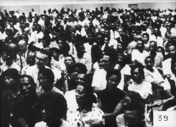 A large group of predominantly African-Americans sitting at a rally or other gathering.