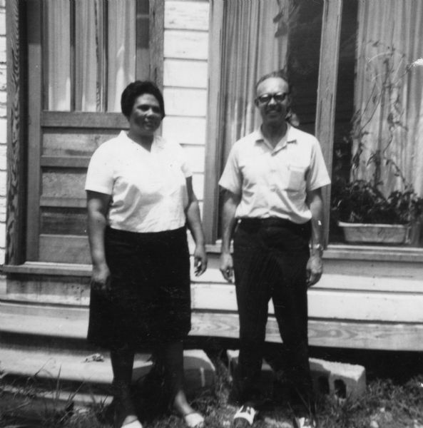 A man and a woman stand next to each other in front of a home in an image taken by a civil rights volunteer.<p>"Mrs. Alyene Quin, one of the most courageous women I have ever met — place of business and home bombed last summer — remains very active in the freedom movement. Head of the MFDP (Mississippi Freedom Democratic Party) in McComb area. Rev. Clare Nesmith, California Methodist minister, my daily companion for two weeks in McComb — a preacher who actually lives by what he preaches."
