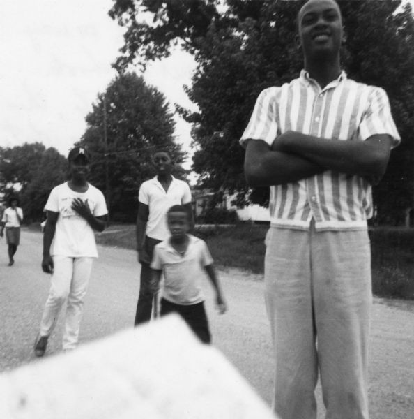A group of Freedom School students walk along a road in an image taken by a civil rights volunteer.

"Freedom School students on way to see the superintendent of schools.  For most if not all students, this trip also took them through a white section of McComb which they had never been before."