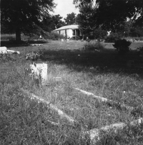 A grave in a segregated cemetery photographed by a civil rights volunteer, who notes that these grounds are cared for "without the benefit of the town's funds" in contrast to the municipally-funded Caucasian cemetery.<p>"This Negro cemetery in McComb must be cared for by unpaid Negroes. Thus the Negroes of McComb experience discrimination from birth to death."