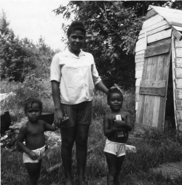 A woman and two children, photographed by a civil rights volunteer.<p>"Mrs. Ernestine Bishop, another most courageous freedom worker.  Last summer she walked alone at night the roads of Summit trying [to] get people to work for freedom. She unsuccessfully tried to send her six-year-old daughter to the all-white school. She has been forced to move several times because of her activities. Presently she and her four children (two pictured) are living with her mother. However there are 25 persons living in the four-room house."