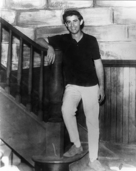 Andrew Goodman standing at the foot of a staircase, age 19, wearing a dark shirt. Andrew Goodman was a civil rights activist and volunteer for the Freedom Summer project. He, along with James Chaney and Michael Schwerner, was murdered in the summer of 1964.