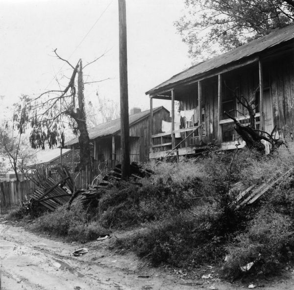 "Damage done by Hurrican [sic] Betsy remains untouched eight months later. Note that tin covering has been torn off far edge of roof. Rain leaks through other parts of the roof as well. Complaints by tenants are ignored."<p>Beekman Quarters housed 81 people in 23 buildings. None of the houses in the neighborhood had running water or gas/electric heating; the neighborhood had 15 outdoor toilets and 11 outdoor water hydrants.