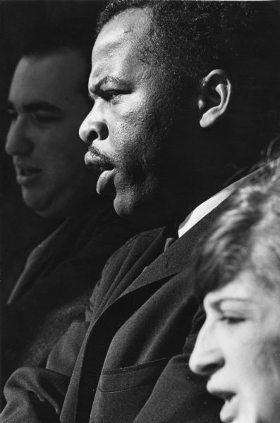 Pictured, from background to foreground: Bobby Feinglass; John Lewis, noted politician and civil rights leader; and Alicia Kaplow, SNCC (Student Nonviolent Coordinating Committee) member and civil rights activist. Taken at an event where John Lewis spoke in Madison, Wisconsin.