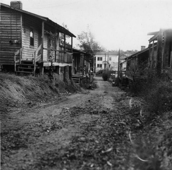 "Overall view of the alley looking toward E. Franklin Street.<p>Griffin Alley houses 12 families in 6 buildings. All residents share 2 hydrants and 4 toilets.