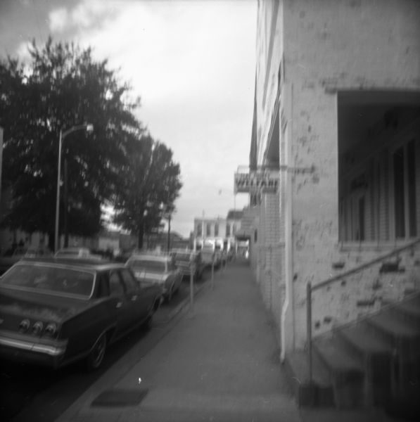 View down sidewalk of the Clay County welfare office. The caption on the back of the image reports that African-Americans who received welfare were treated poorly and that "in Tibbee have to work in the field of the agent to get a check."