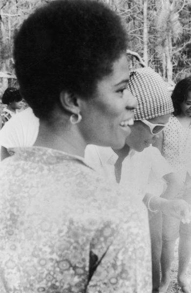 Three SNCC (Student Nonviolent Coordinating Committee) workers in an image tentatively identified as taken at a barbeque hosted by Mr. Steptoc for SNCC staff in McComb, Mississippi.<p>They are identified left to right as: Janet Jamott [Jemott], Lorne Kreps, and Dorie Ladner.