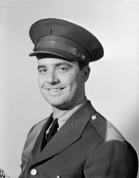 Quarter-length publicity portrait of Robert Doyle smiling, dressed in his uniform. This image was published with some of his articles in the <i>Milwaukee Journal</i> and other Wisconsin newspapers. Robert Doyle was a civilian war correspondent for the <i>Milwaukee Journal</i> during World War II, covering the experiences of Wisconsin troops in the 32nd "Red Arrow" Division, an infantry division of the United States Army National Guard. The "Red Arrow" Division consisted mainly of soldiers from Wisconsin and Michigan.