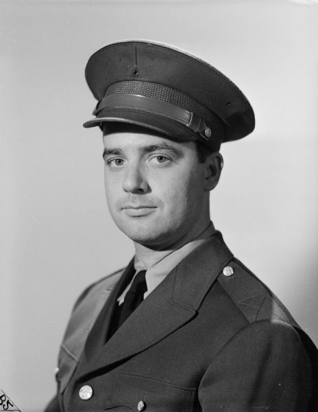 Quarter-length publicity portrait of Robert Doyle, dressed in his uniform. This image was published with some of his articles in the <i>Milwaukee Journal</i> and other Wisconsin newspapers. Robert Doyle was a civilian war correspondent for the <i>Milwaukee Journal</i> during World War II, covering the experiences of Wisconsin troops in the 32nd "Red Arrow" Division, an infantry division of the United States Army National Guard. The "Red Arrow" Division consisted mainly of soldiers from Wisconsin and Michigan.