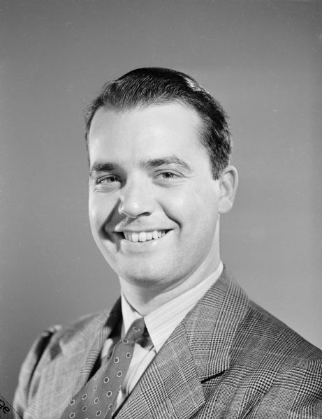 Quarter-length publicity portrait of Robert Doyle smiling, dressed in a suit. This image was published with some of his articles in the <i>Milwaukee Journal</i> and other Wisconsin newspapers. Robert Doyle was a civilian war correspondent for the <i>Milwaukee Journal</i> during World War II, covering the experiences of Wisconsin troops in the 32nd "Red Arrow" Division, an infantry division of the United States Army National Guard. The "Red Arrow" Division consisted mainly of soldiers from Wisconsin and Michigan.