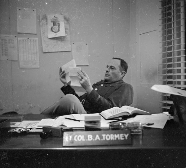 Colonel B. Tormey, Chief Censor — Southwest Pacific Area, sits in his well-lighted office at Camp Cable, near Brisbane, Australia. Robert Doyle's articles and photographs had to be approved by the military censors before publication in the newspapers.