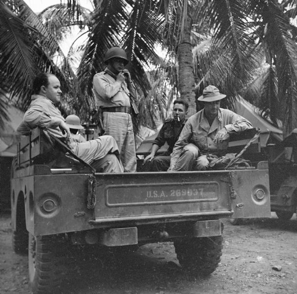 War correspondents in Port Moresby wait in the back of a jeep the night before a paratroop landing near Lae, a Japanese-held airfield in New Guinea (present day Papua New Guinea).