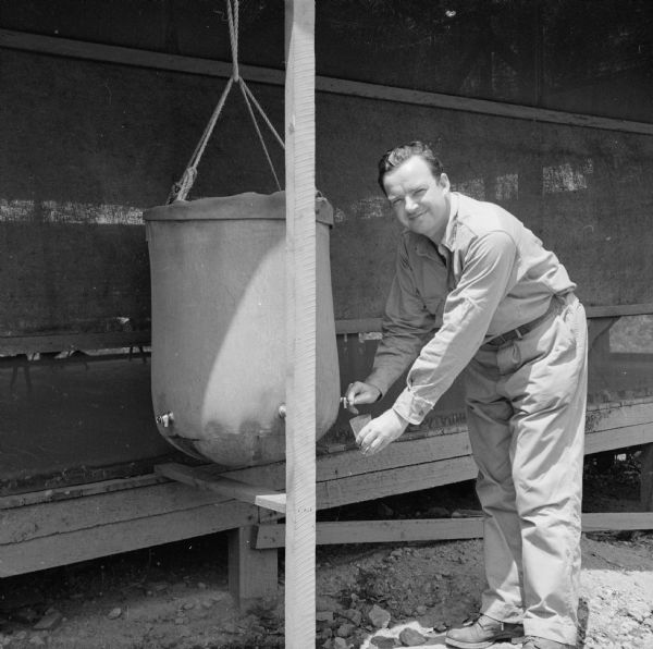 Private First Class Harry Glass, Jr., of Grand Rapids, Michigan, gets a drink of water at the lister bag. A lister bag (also spelled lyster bag) is a device used to disinfect drinking water. Behind him can be seen the FAF Press Hut, located in New Guinea (present day Papua New Guinea). Robert Doyle notes that Private Glass was a "former Democratic State Representative, National Committeeman of the Young Democrats and High School National Public Speaking Champion. Now AG - Personnel - FAF Adv. Exch."