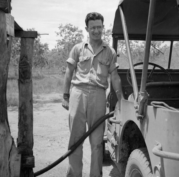 Motor Pool Dispatcher Sergeant Alex Petro of Racine, Wisconsin, fuels a jeep near Port Moresby, New Guinea (present day Papua New Guinea). He is a member of the 245th Bomb Group (B-25) Squadron.