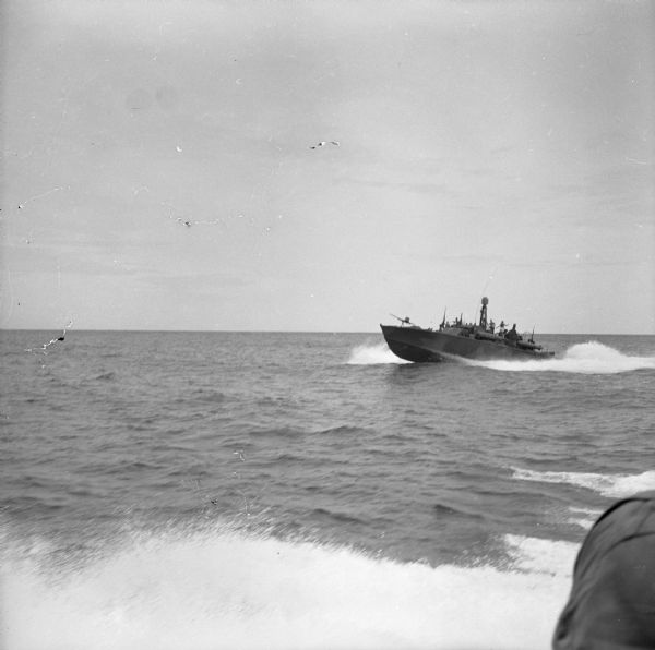 View of a PT (Patrol Torpedo) boat from another PT boat, off of the north coast of New Guinea (present day Papua New Guinea). PT (Patrol Torpedo) boats were a variety of torpedo-armed fast attack craft used to attack larger surface ships.