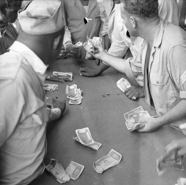 Soldiers play a crap game at an air base near Port Moresby, New Guinea (present day Papua New Guinea).