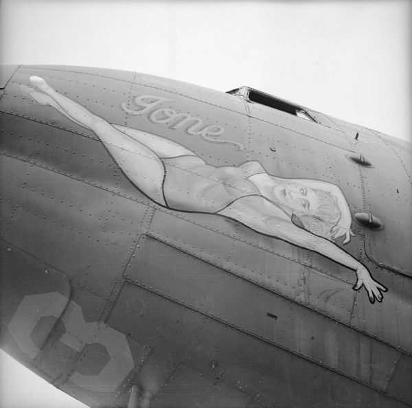 A warplane with nose art depicting a reclining woman in the "pin-up style" with the text, "Gone," at an airbase near Port Moresby, New Guinea (present day Papua New Guinea).