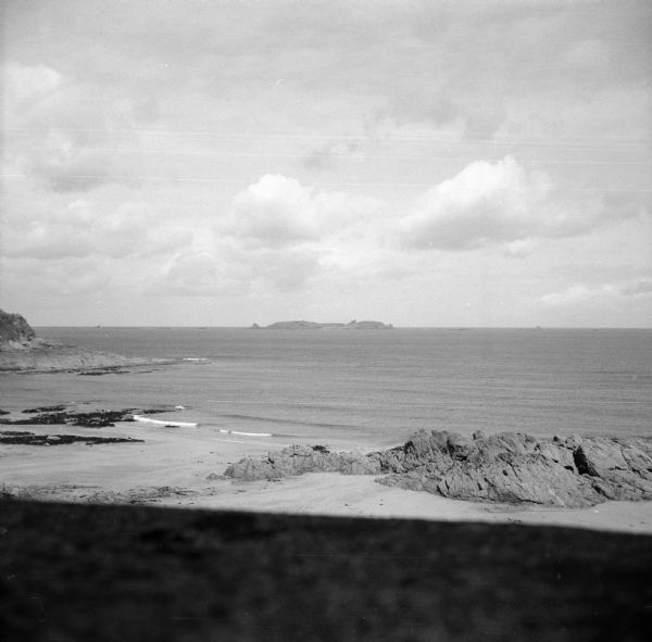 View from shoreline of Cezembre Island, just north of Saint-Malo on the north coast of France. It was German-occupied until the Allies mounted an operation to seize the island starting August 21st. A small plume of smoke is coming from the center of the island. The Allies made five trips under a white truce flag before the Germans obtained permission to surrender. They surrendered on Saturday evening, September 2nd.