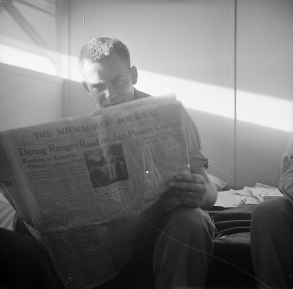 Major James Baird of Suring, Wisconsin, reads the <i>Milwaukee Journal</i> in Robert Doyle's quarters on Guam in the South Pacific.