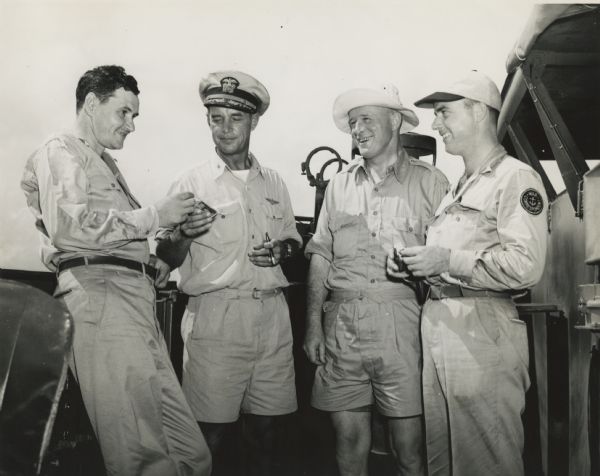 Robert Doyle poses with two other journalists and a ship's captain on the deck while aboard an escort carrier near Japan. Identified (left to right) are Al Dopking, war correspondent for the Associated Press; Ship's Captain Percy H. Lyon of Sioux City, Iowa; William Matthews, Editor and Publisher of the Tucson (Arizona) <i>Daily Star</i> and Robert Doyle of the <i>Milwaukee Journal</i>, in Wisconsin.