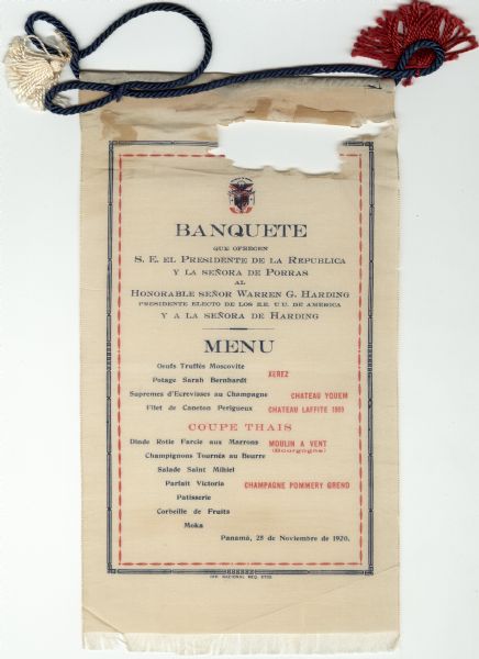 Menu for a banquet given by the President of Panama for President-Elect Warren G. Harding in Panama. Printed on a length of fringed silk with a blue twisted cord and red and white tassels at the top.