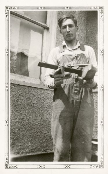 Alvin Elmer, age 15, holds a model airplane and coal truck that he made. His teacher at Farmer's Grove School wrote on the reverse of the photograph, "This student shows special interest in manual arts work."