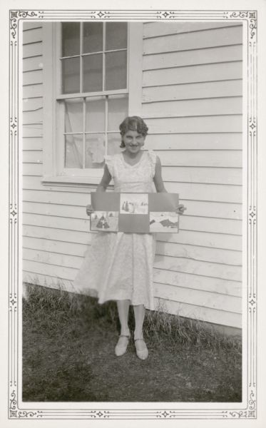 Arlene Annette Elmer, 14, poses with three of her drawings alongside the Farmer's Grove School. Her teacher wrote on the reverse of this photograph that she was "very much interested in art and music."