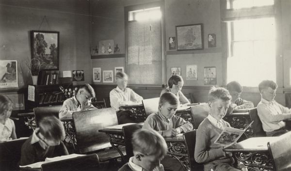 Pupils at the Northey School, District No. 7, read and work at their desks. Student artwork and other prints decorate the walls.