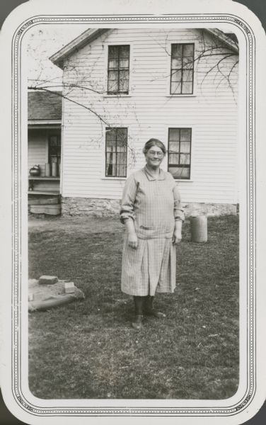 Mrs. Lou Stark, president of the PTA at Lower Big Creek School, poses in front of her farmhouse.