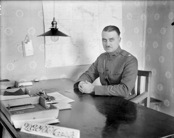 Portrait of Lieutenant Colonel P.S. Morris, the commanding officer of the 310th United States Army Engineer Corps, in uniform and sitting at his desk.