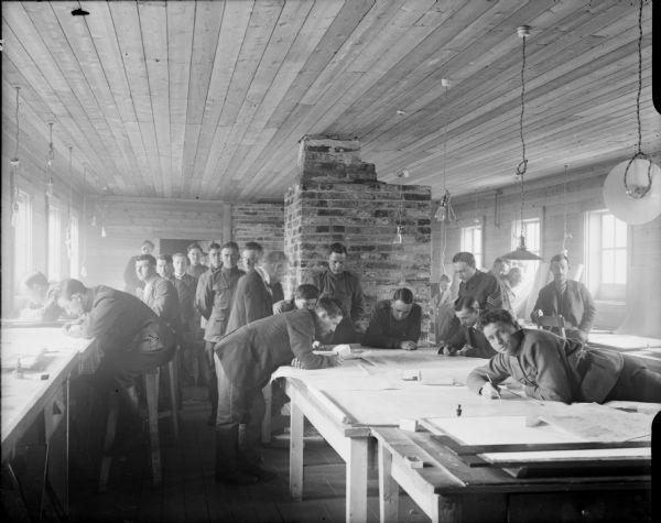 The map drafting room for the 310th United States Army Engineer Corps, with both civilian and British and American soldiers in the room.