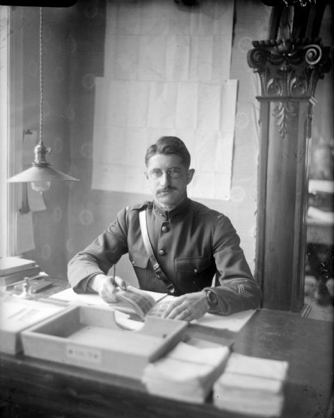 Seated portrait of Lieutenant Gray from Company C of the 310th United States Engineer Corps, in uniform posed at a desk.