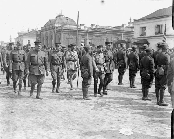A group of American soldiers stand at attention with their backs to officers of the Allied forces in Siberia, Russia. Some of the officers are: Lieutenant Colonel P.S. Morris (second from the left), Brigadier General Wilds P. Richardson (fourth from the left), Russian General Lavr Kornilov (eighth from the left).