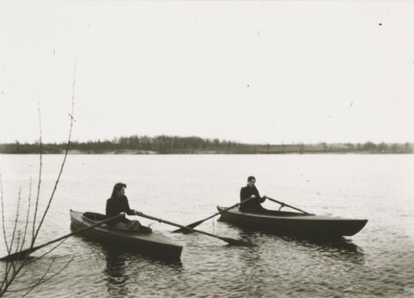 Mrs. Kern and Jessie rowing boats on unidentified lake. The far shoreline can be seen in the background.