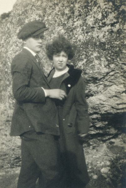 Young couple standing in front of a large rock face.