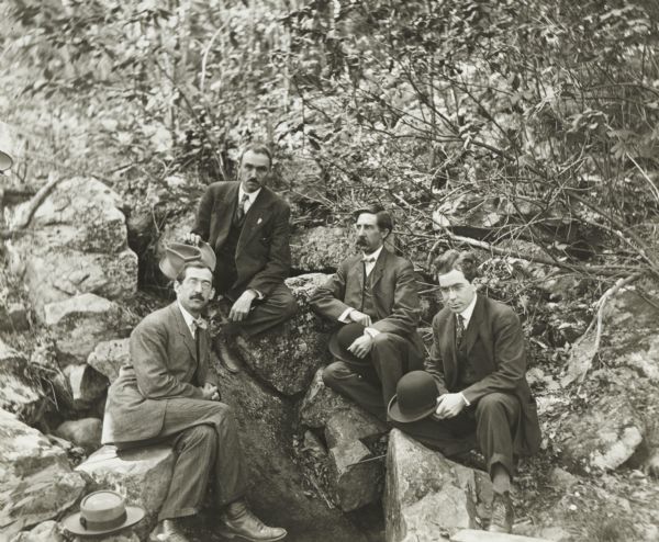 Four men, identified as Charles E. Brown of Milwaukee, Joyce W. Caron, H.E. Cole (second from right), and A.B. Stout, all of Baraboo, rest at Messenger's Spring at the south end of Devil's Lake State Park.
